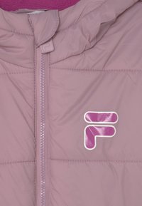 Giacca imbottita rosa con zip frontale, caratterizzata da un logo lucido in bianco e viola. Tessuto liscio con una morbida fodera interna.