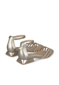 Chaussures argentées métalliques à bride de cheville avec un talon en bloc triangulaire, ouverte à l'avant, et plusieurs brides entrecroisées ornées de petits strass.