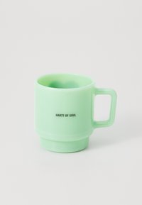 Taza de cerámica verde menta con forma cilíndrica, un asa robusta y "HARTT OF SOUL" impreso en negro en el lateral. Textura suave.
