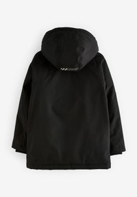 Giacca nera con cappuccio, caratterizzata da una texture liscia e da un accento riflettente sulla parte superiore della schiena. Maniche lunghe e orlo dritto.