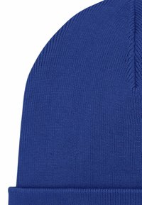 Cappello a maglia blu con trama a costine, caratterizzato da una visiera piegata e una parte superiore senza cuciture. Il materiale è probabilmente un tessuto morbido ed elastico.