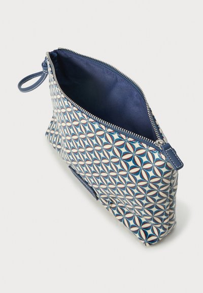 Lynlås pung med blåt og hvidt geometrisk mønster, mørkeblå stofindvendigt og en lille løkke håndtag på siden.