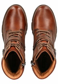 Botas de tobillo de cuero marrón con un acabado suave. Presentan costuras decorativas, cordones en la parte frontal y una cremallera lateral con herrajes metálicos.