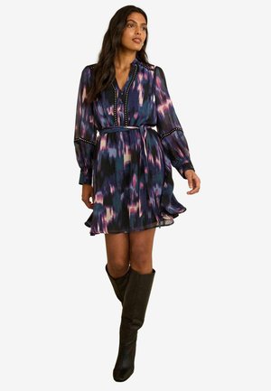 Langärmliges Kleid aus dunklem Stoff mit einem lila und blauen abstrakten Muster, tailliertem Bund und dekorativen Knöpfen am Ausschnitt.