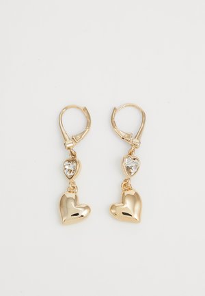 Los pendientes en forma de corazón en tono dorado presentan un diseño colgante con un acento de gema clara. Textura suave con acabado brillante. Livianos y con cierre de gancho.