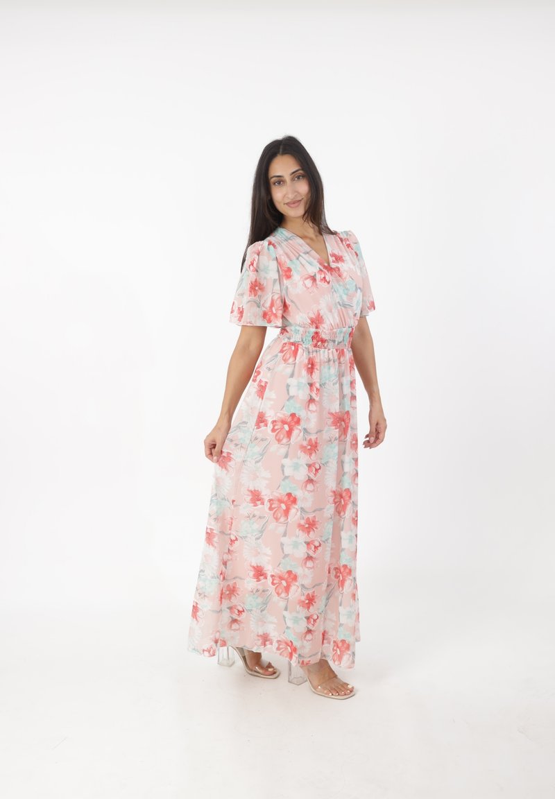 Robe maxi à motifs floraux avec une taille cintrée, manches courtes et flottantes, en rose pastel avec des fleurs rouges et aqua, fabriquée en tissu léger et transparent.