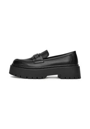 Des mocassins en cuir noir avec une semelle en plateforme épaisse, arborant un design cousu et une sangle décorative à travers le coup de pied.