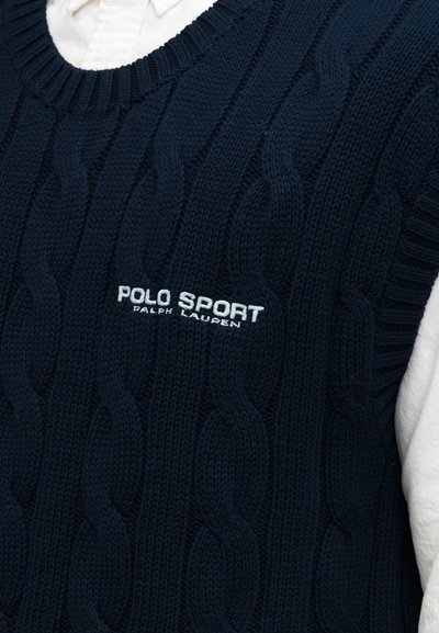 Μπλε σκούφο ζακάρ χωρίς μανίκια με κεντημένο το λογότυπο "Polo Sport Ralph Lauren" στο στήθος, φορεμένο πάνω από λευκό πουκάμισο με γιακά.