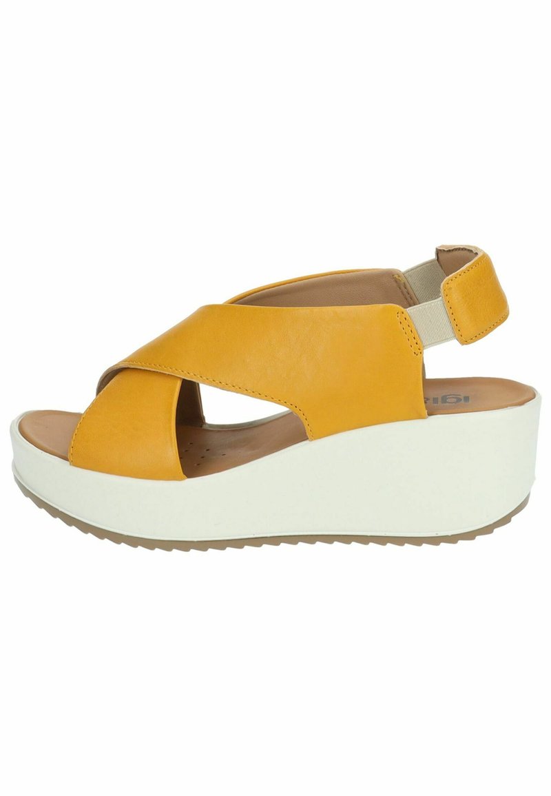 Sandalo wedge in pelle gialla con design a fasce incrociate, cinturino posteriore regolabile e suola piattaforma bianca, caratterizzato da una superficie texturizzata.