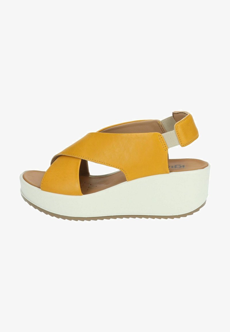 Sandalo wedge in pelle gialla con design a fasce incrociate, cinturino posteriore regolabile e suola piattaforma bianca, caratterizzato da una superficie texturizzata.