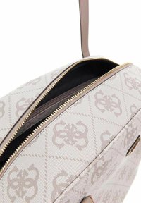 Sac à main à motifs beige avec une fermeture éclair, présentant un extérieur texturé et des accents en métal doré. L'intérieur est noir.