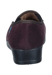 Burgundy suede slipper with a rounded heel, a black textured sole, and a cushioned interior, featuring a stitched edge and a seamless design.