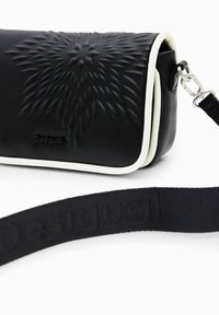 Borsa a tracolla nera in pelle con superficie testurizzata, bordi bianchi e accessori in argento. Include una tracolla nera con un design del logo impresso.