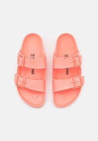 Sandalias de goma rosa con dos hebillas ajustables, plantilla con contorno y suela texturizada. Tamaño 38 indicado en la plantilla.