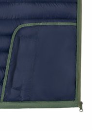 Innenbereich einer marineblauen und grünen gesteppte Jacke mit einem Reißverschlussrand und einer kleinen rechteckigen Innentasche auf der linken Seite.