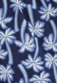 Jūros kariniai audiniai su gėlių raštu, kuriame yra baltų ir šviesiai mėlynų palmų lapų bei tekstūruotų stiebų. Dizainas yra tankus ir repetityvus.