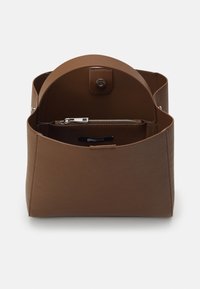 Brun konstläderväska med rundad topp, magnetisk knäppning och ett zippered fack inuti. Slät textur med rena linjer.