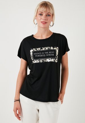 Zwarte t-shirt met korte mouwen, gemaakt van zachte stof, met een zilveren folie tekstontwerp omgeven door een panterprintpatroon op de voorkant.