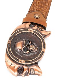 Bronzen riemgesp in de vorm van een schedel met gedetailleerde schedelmotieven, een gestructureerd oppervlak en een bruine leren band met een patroonafwerking.