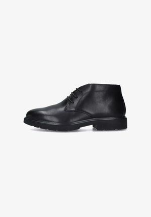 Stivaletto alla caviglia in pelle nera con texture liscia, punta rotonda e allacciatura a tre occhielli, dotato di una suola in gomma resistente.