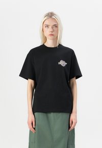 Black cotton t-shirt with short sleeves, featuring a small printed logo on the chest in a contrasting color. Simple, relaxed fit.