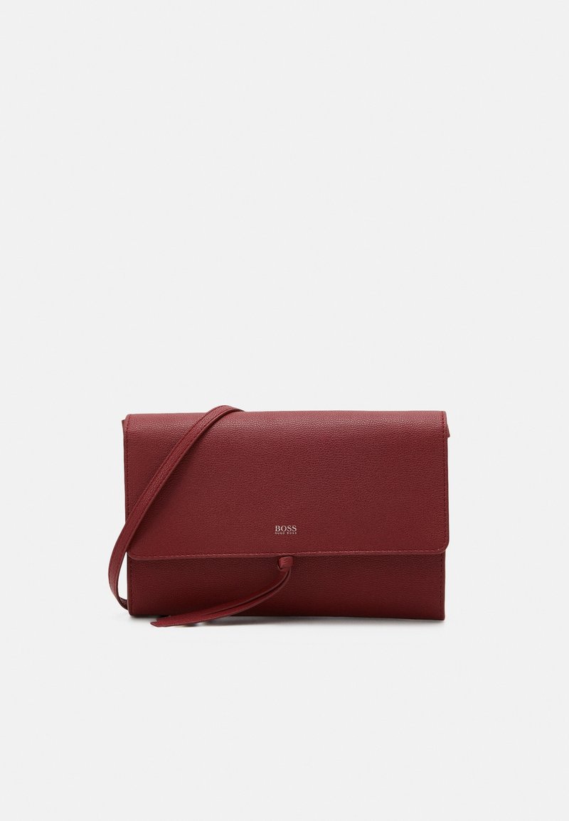 Borsa a pochette rossa in pelle con un design sottile, dotata di chiusura a patta e tracolla regolabile. Logo impresso sulla parte anteriore.