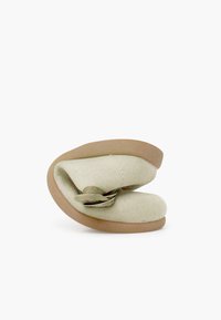 Grüner Textilschuh mit geschwungenem Design, weicher Textur und beige-gummierter Sohle. Verfügt über eine dekorative Schleifenakzent auf der Oberseite.