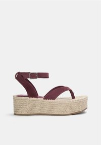 Burgundy mockasinsandaler med kilklack, två korsade remmar, ankelspänne och plattformssula omhuldad med jute. Platt yttersula med texturerad finish.