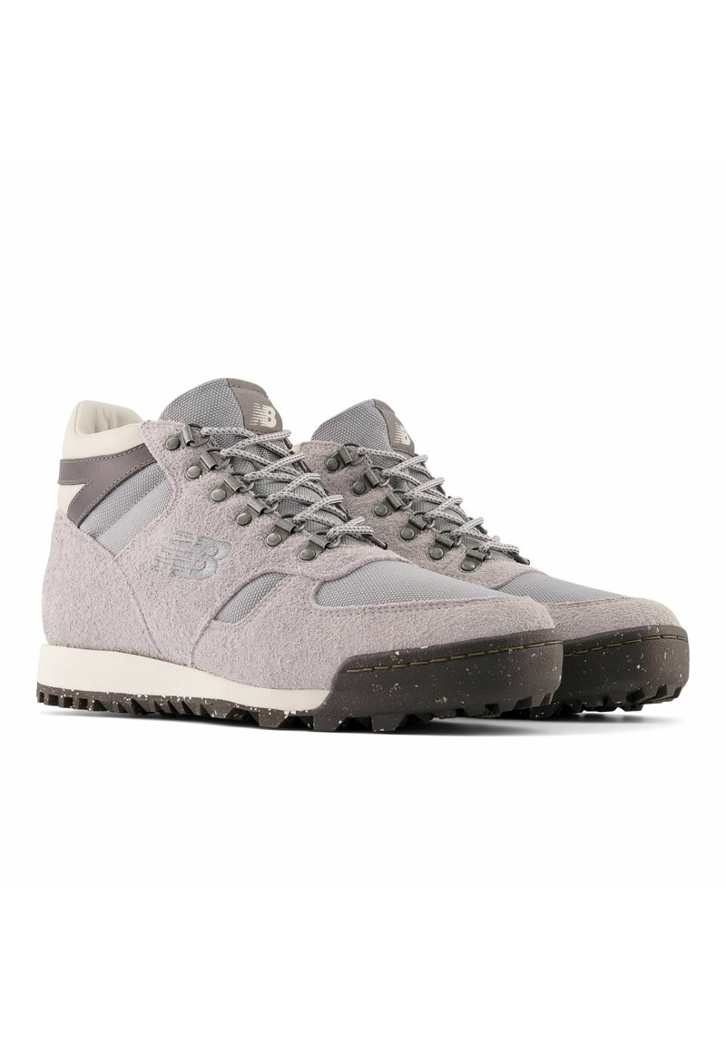 Grijze wandelschoenen met een mix van gestructureerd suede en mesh-materialen, voorzien van een gevoerde kraag, vetersluiting en een robuuste rubberen zool.