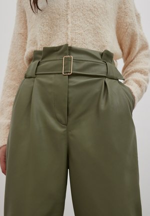 Olijfgroene high-waisted broeken van nepleer, met een brede riem en een rechthoekige gouden gesp, en een geplooid ontwerp aan de voorkant.