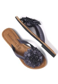 Chanclas moradas con un adorno floral, tiras sintéticas suaves, plantilla acolchada de color beige y suela de goma negra.