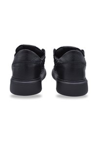 Czarne trampki mają teksturowaną skórzaną cholewkę z gładką gumową podeszwą, zaokrąglonym noskiem oraz elastycznymi bocznymi wstawkami dla wygody noszenia.