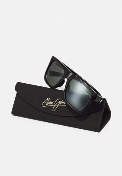 Crne Maui Jim sunčane naočale s tamnim lećama, pravokutnog oblika i debelim okvirom, odmaraju se na crnom kutiji s zlatnim logotipom.
