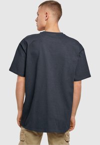 Tumehall oversized T-särk lühikeste varrukatega, ribakujundusega ja klassikalise ümmarguse kaelusega. Omab mugavat ja vabakujulist istuvust.