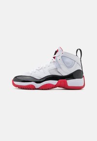 Chaussures de sport blanches avec une boîte à orteils en cuir verni noir, une semelle rouge et des accents en maille. Présente des textures contrastées et un design à lacets.