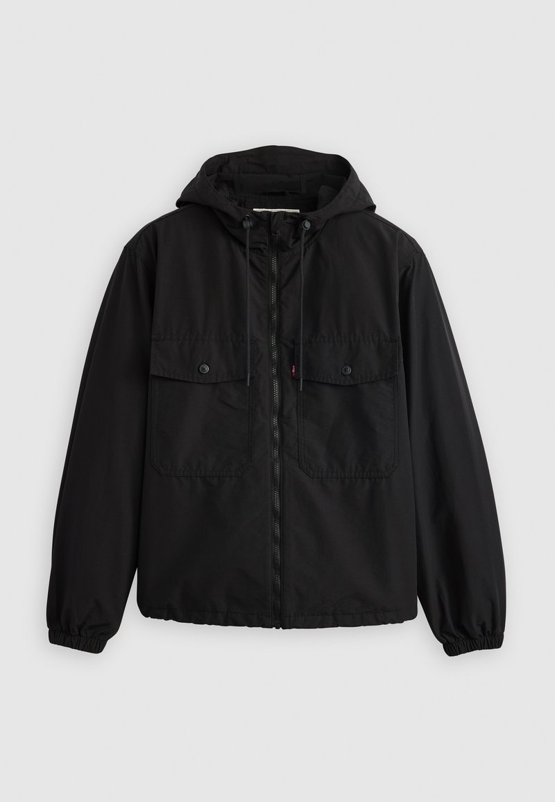 Chaqueta con capucha negra hecha de tejido suave. Presenta dos bolsillos frontales con solapa, puños elásticos y un cierre de cremallera de longitud completa. Diseño sencillo.