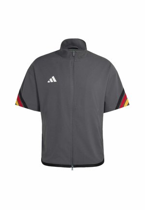 Giacca corta grigio scuro con zip e colletto alto, logo Adidas bianco sul petto e strisce nere, rosse e gialle sulle maniche.