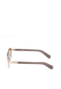 Lunettes de soleil Adidas teintées en marron avec monture métallique dorée et branches translucides marron, présentées à plat sur fond blanc.