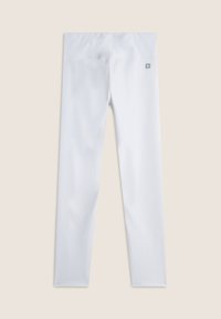 Leggings atletici bianchi realizzati in un tessuto morbido e elastico, con un'ampia cintura elasticizzata e un piccolo logo vicino alla vita.