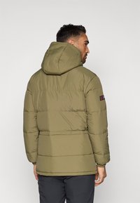 Maslinasto zelena zimska jakna s kapuljačom, s horizontalno ušivenim sekcijama, elastičnim rukavima i logom na lijevom rukavu.
