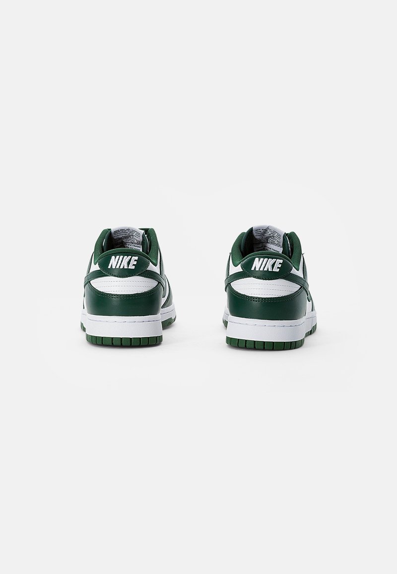 Zapatillas Nike en verde y blanco con parte superior de cuero, cuello acolchado y suela de goma. Las características incluyen un talón con marca y texturas en contraste.