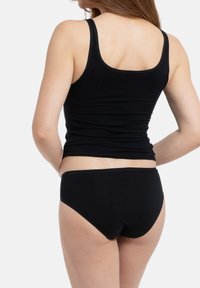 Schwarzes Tanktop und Bikini-Set, das ein einfaches Design mit weichem Stoff aufweist. Das Oberteil hat breite Träger, während der Bikini einen klassischen Schnitt hat.