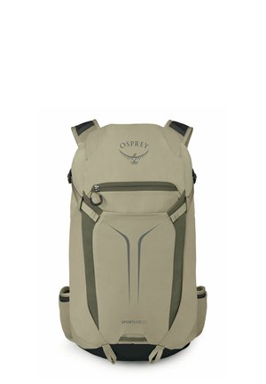 Sac à dos beige Osprey Sportlite 22 avec poche avant zippée, poignées supérieures, sangles latérales et panneau inférieur noir.