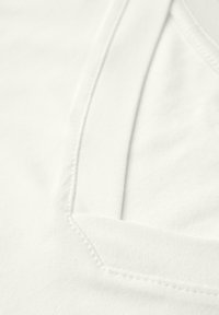 T-shirt bianca in cotone con scollo a V, texture liscia e tasca cucita sul lato sinistro.