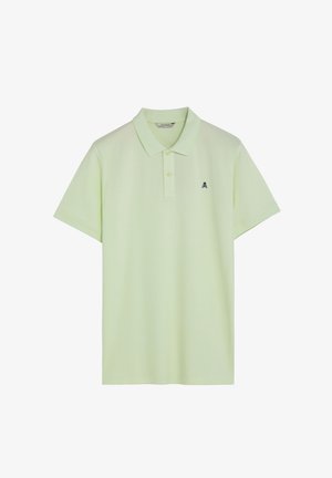 Polo de manga corta color verde claro con cuello, tapeta de dos botones y pequeño logo negro de calavera y huesos cruzados en el pecho izquierdo.