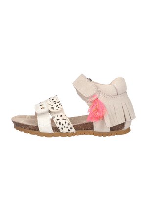 Beige en witte kindersandaal met twee voorste bandjes, enkelbandje met franjes, roze kwastje en gestructureerde bruine zool.