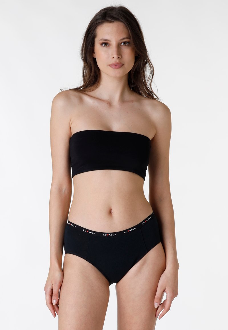 Top bandeau nero senza spalline abbinato a slip a vita alta coordinati con un elastico in vita marchiato. Tessuto liscio, design semplice.