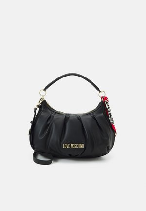 Sac à main en simili cuir noir avec un design plissé, matériel doré et une courte poignée. Comprend un pompon coloré détachable avec logo.