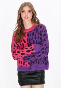 Sweter dzianinowy w różowym i fioletowym kolorze z czarnym nadrukiem w panterkę. Posiada okrągły dekolt i długie rękawy, wykonany z miękkiego materiału o teksturowanej powierzchni.