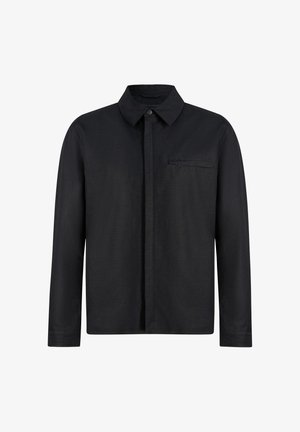 Chemise noire à manches longues avec col, boutons avant dissimulés et une poche poitrine unique avec une fermeture éclair horizontale.